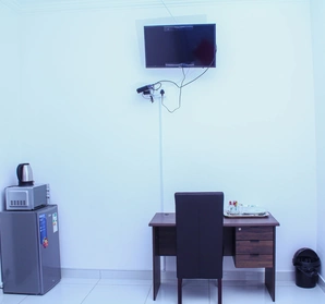 A room with a desk and chair and tv