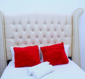 A comfortable bed showing two red pillows